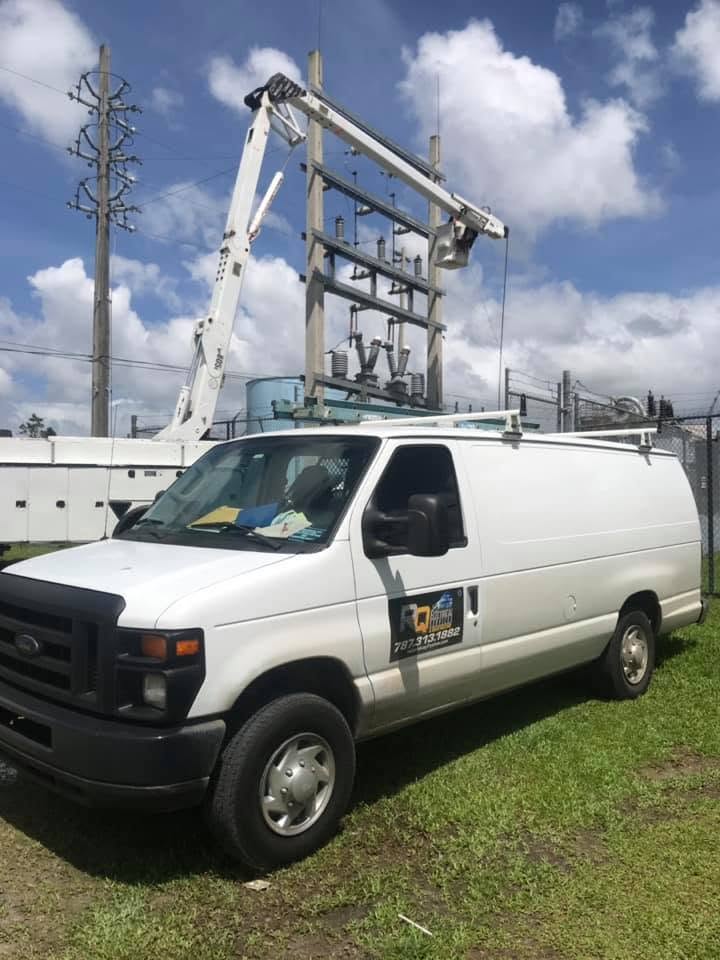 Van de servicio rotulada de RQ Electrical Services estacionada junto a una subestación.
